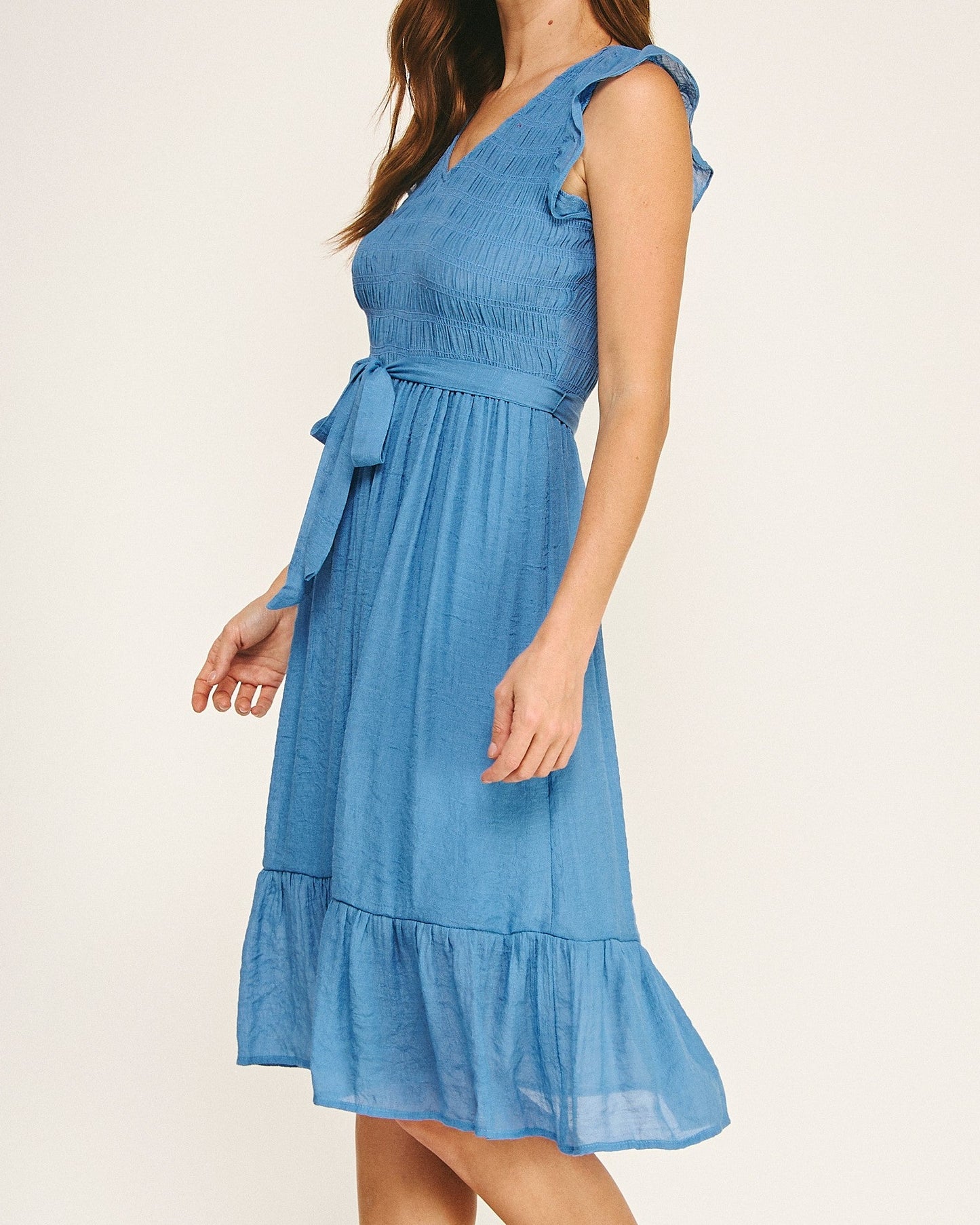 Woman wearing a blue dress on a plain background