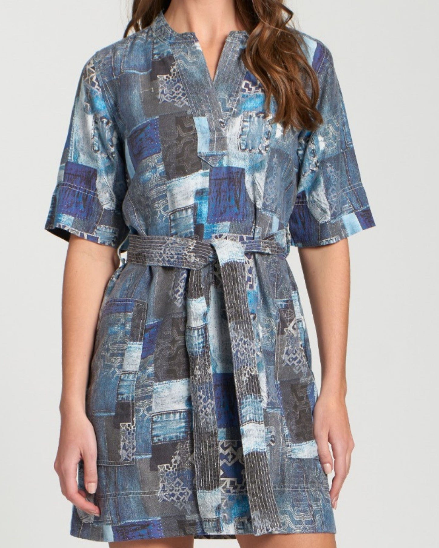 Woman wearing a blue patchwork dress on a white background