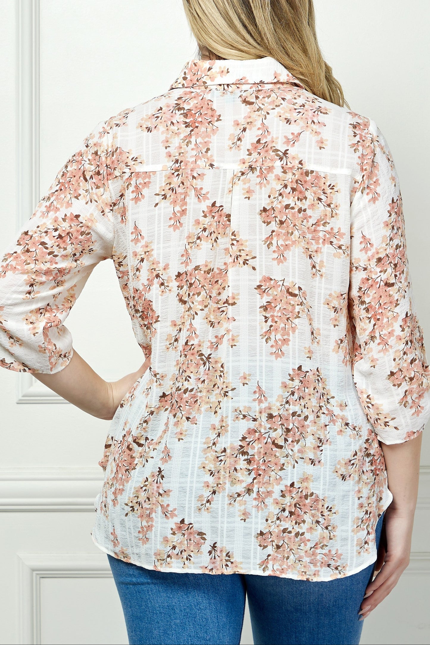 Woman wearing a floral blouse with a neutral background