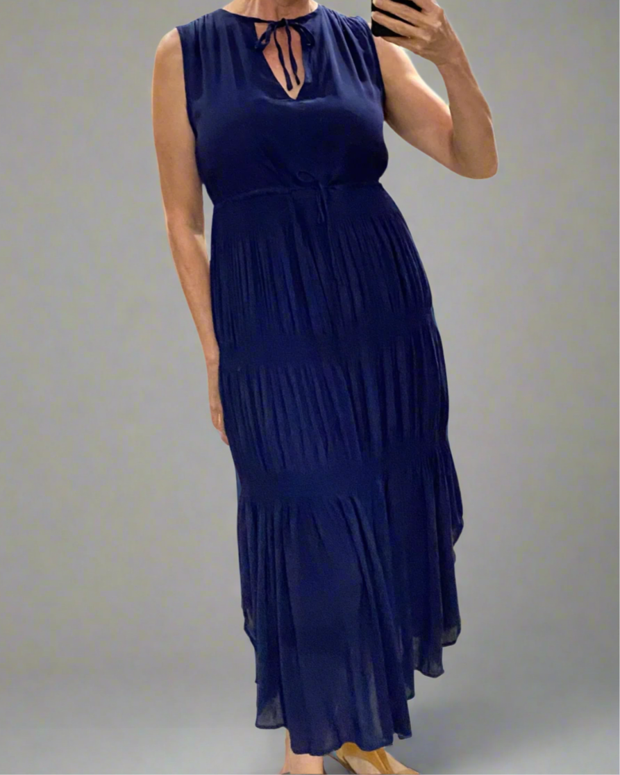 Woman wearing a navy blue dress against a plain background