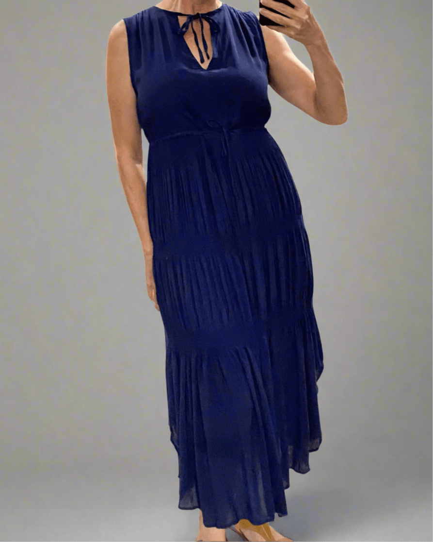 Woman wearing a navy blue dress against a plain background