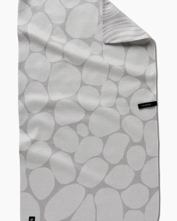 Folded fabric with a pattern of gray stones on a white background