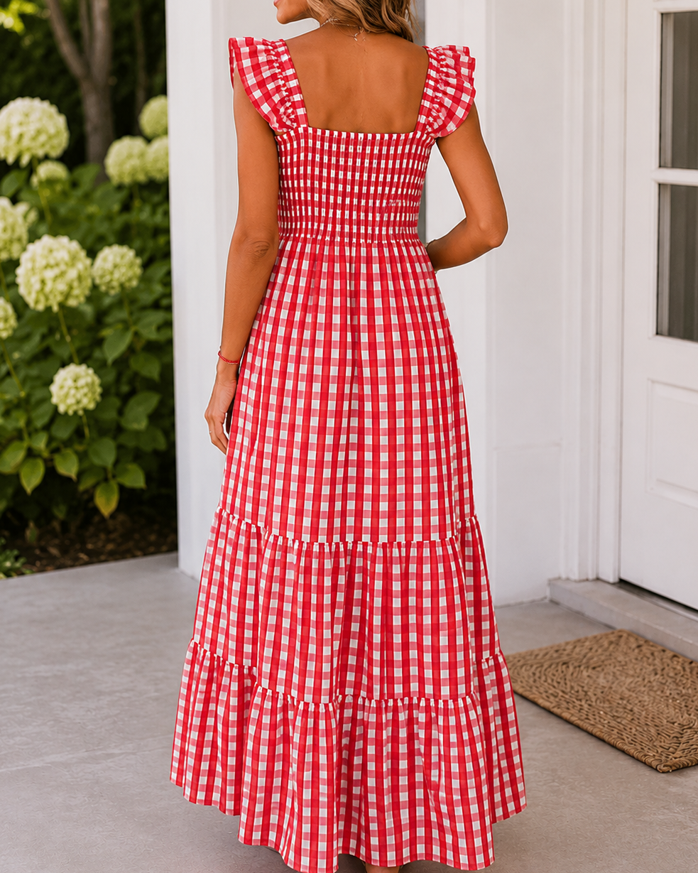 Woman wearing a red and white checkered dress standing on a porch.