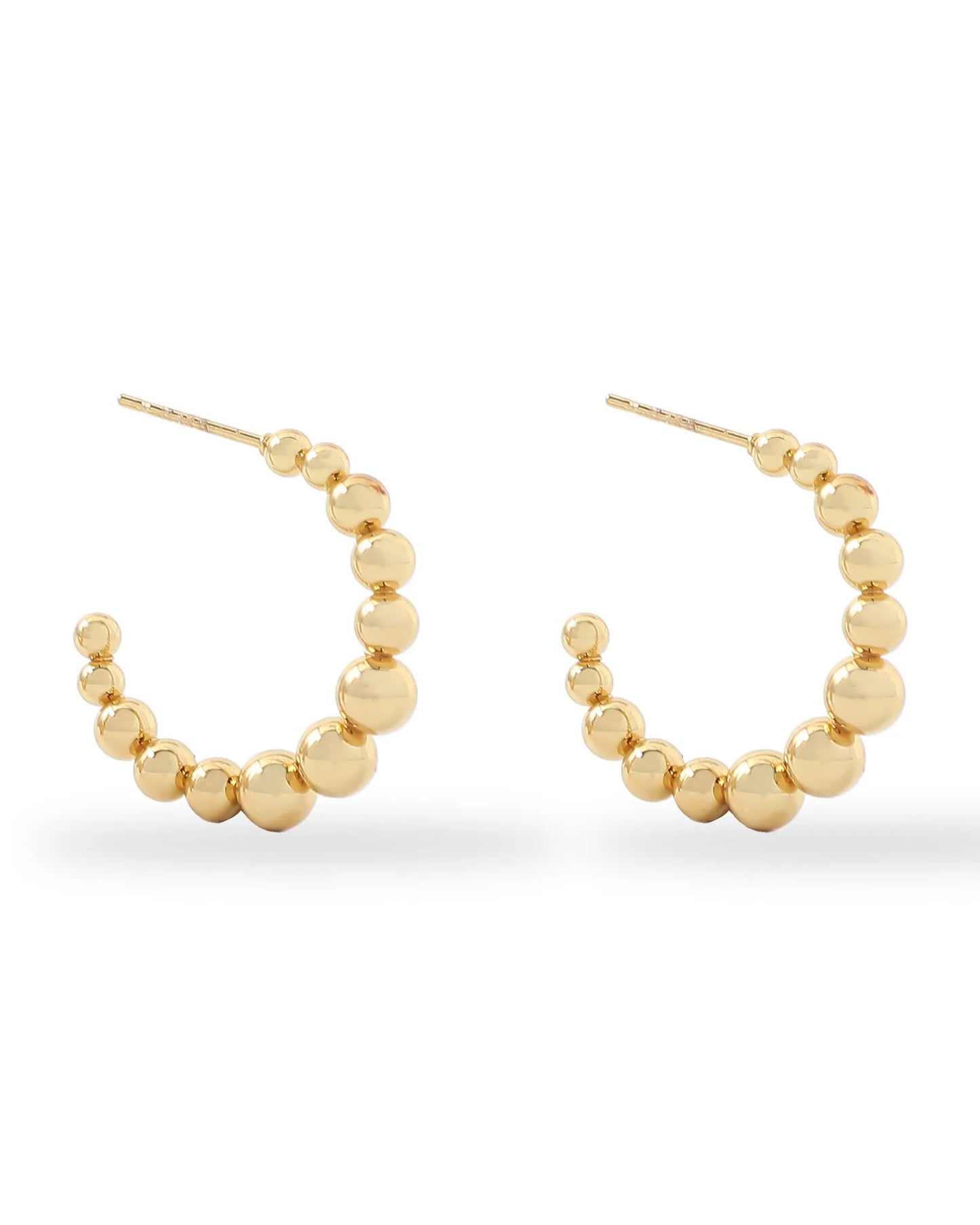 Gold hoop earrings with bead detailing on a white background