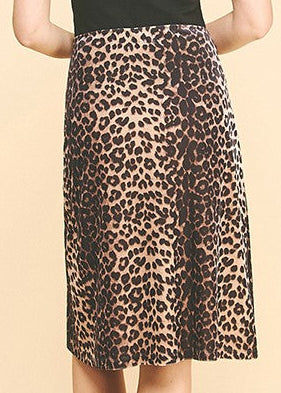 Woman wearing a black tank top and leopard print skirt on a beige background