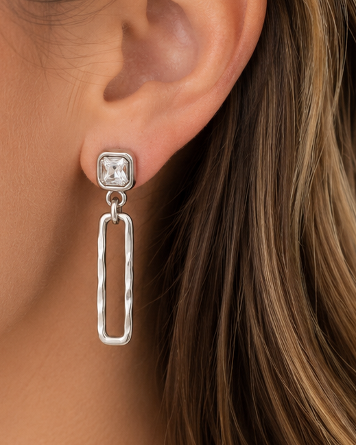 Close-up of a woman wearing silver earrings with a blurred background