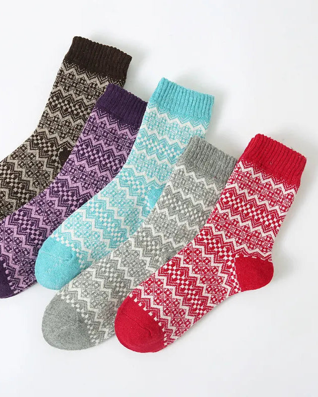 Five patterned socks in different colors on a white background