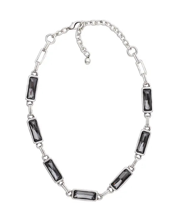 Silver necklace with black gemstone accents on a white background