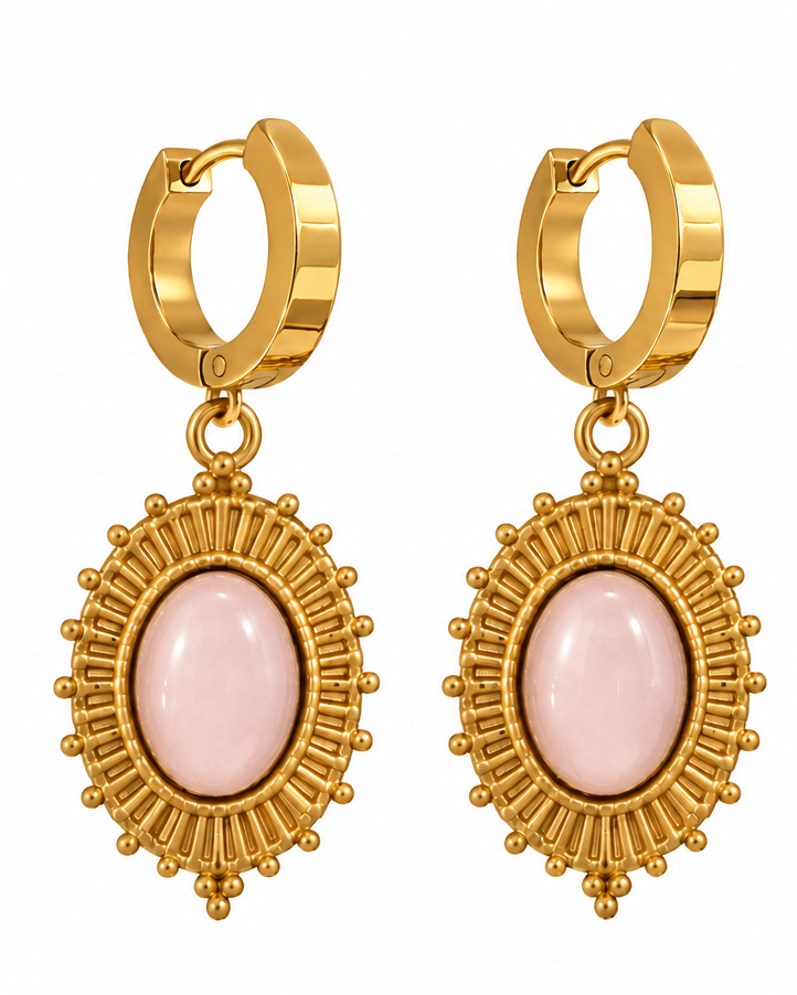 Gold huggie hoop earrings with oval pink cabochon stones in sunburst-style frames, shown both as a pair on a white background and worn on a model's ear.