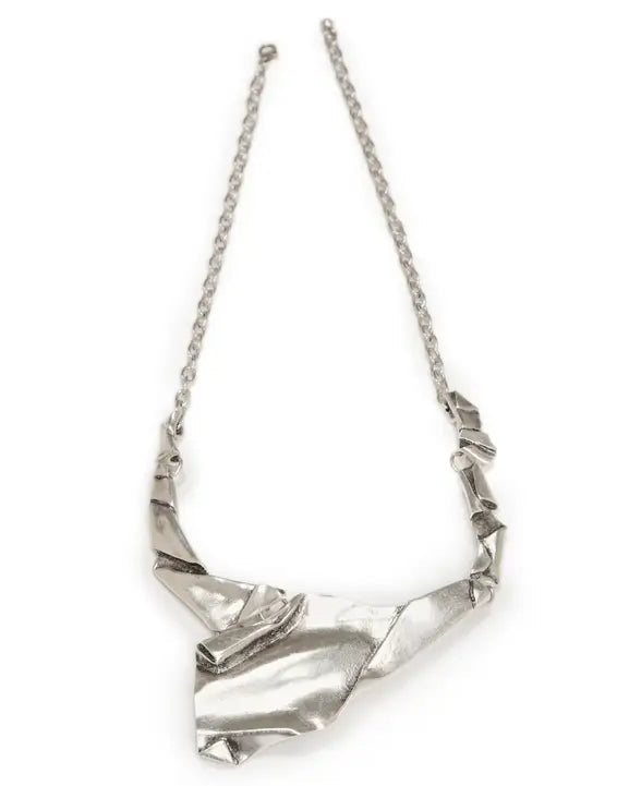 Silver necklace with a geometric pendant on a white background