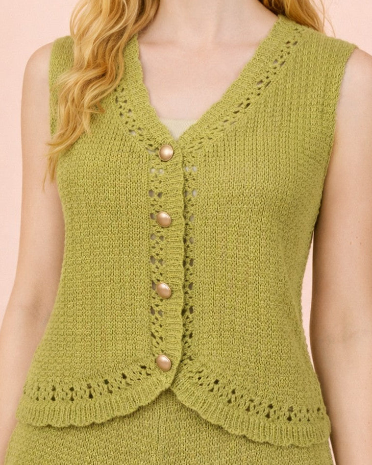 Woman wearing a green knitted vest against a pink background