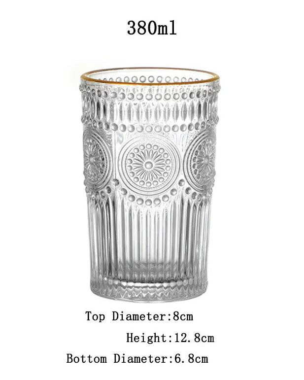 Clear glass tumbler with decorative pattern on a white background