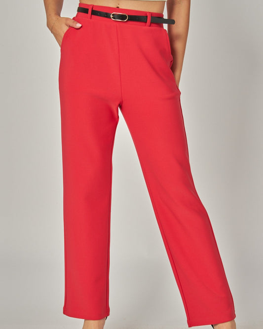 Red pants with a black belt worn by a person on a plain background