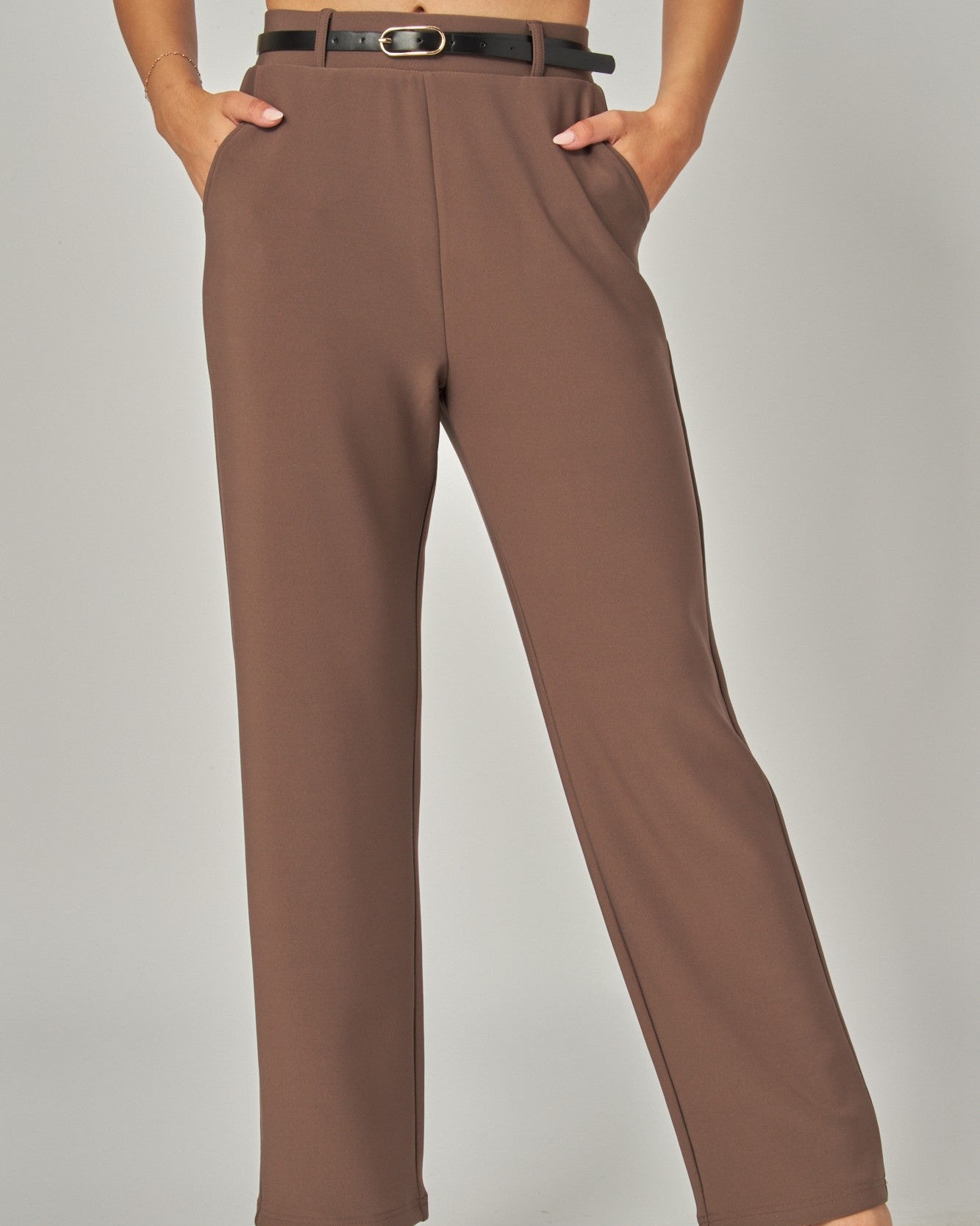 Brown pants worn by a person on a plain background