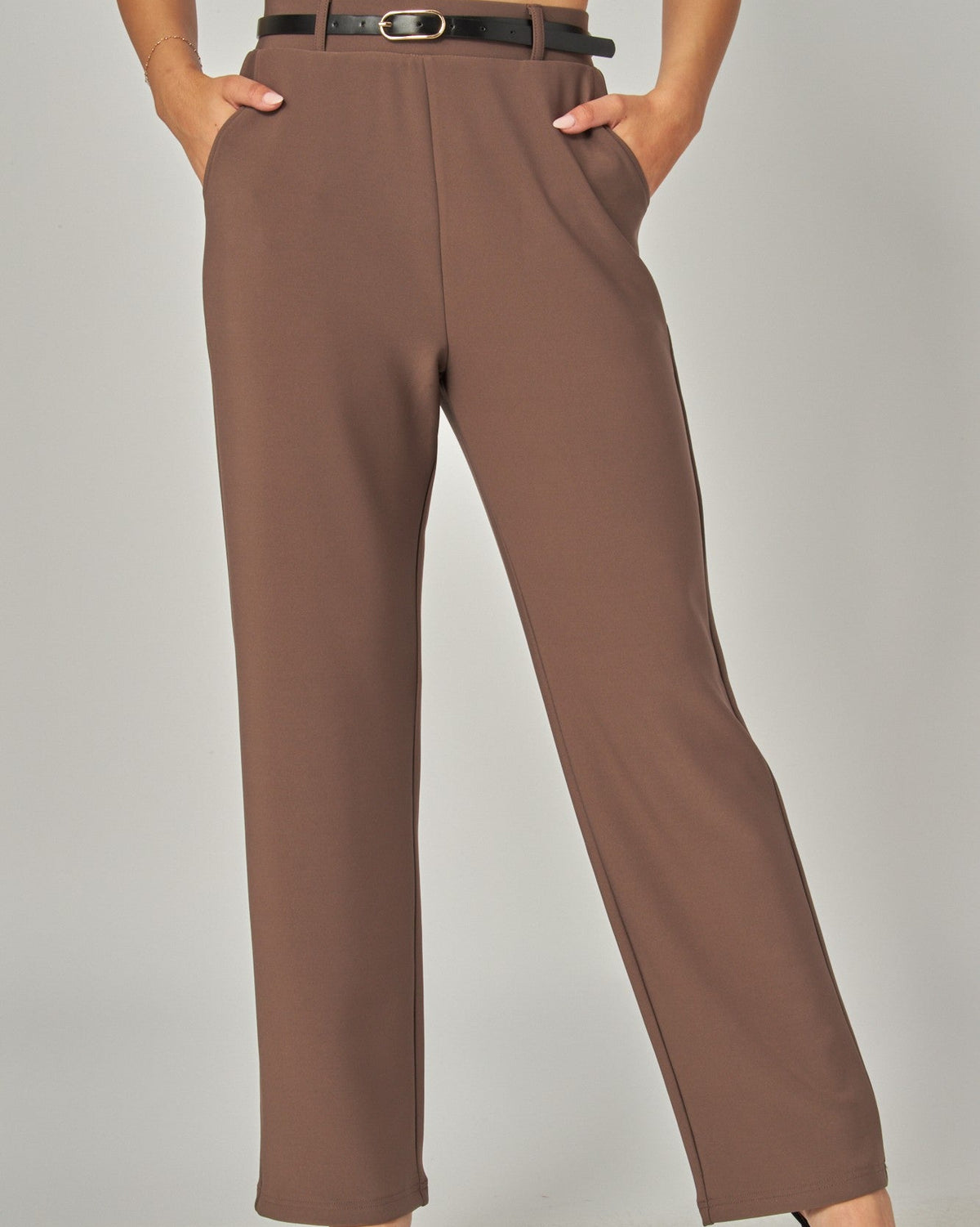 Brown pants worn by a person on a plain background