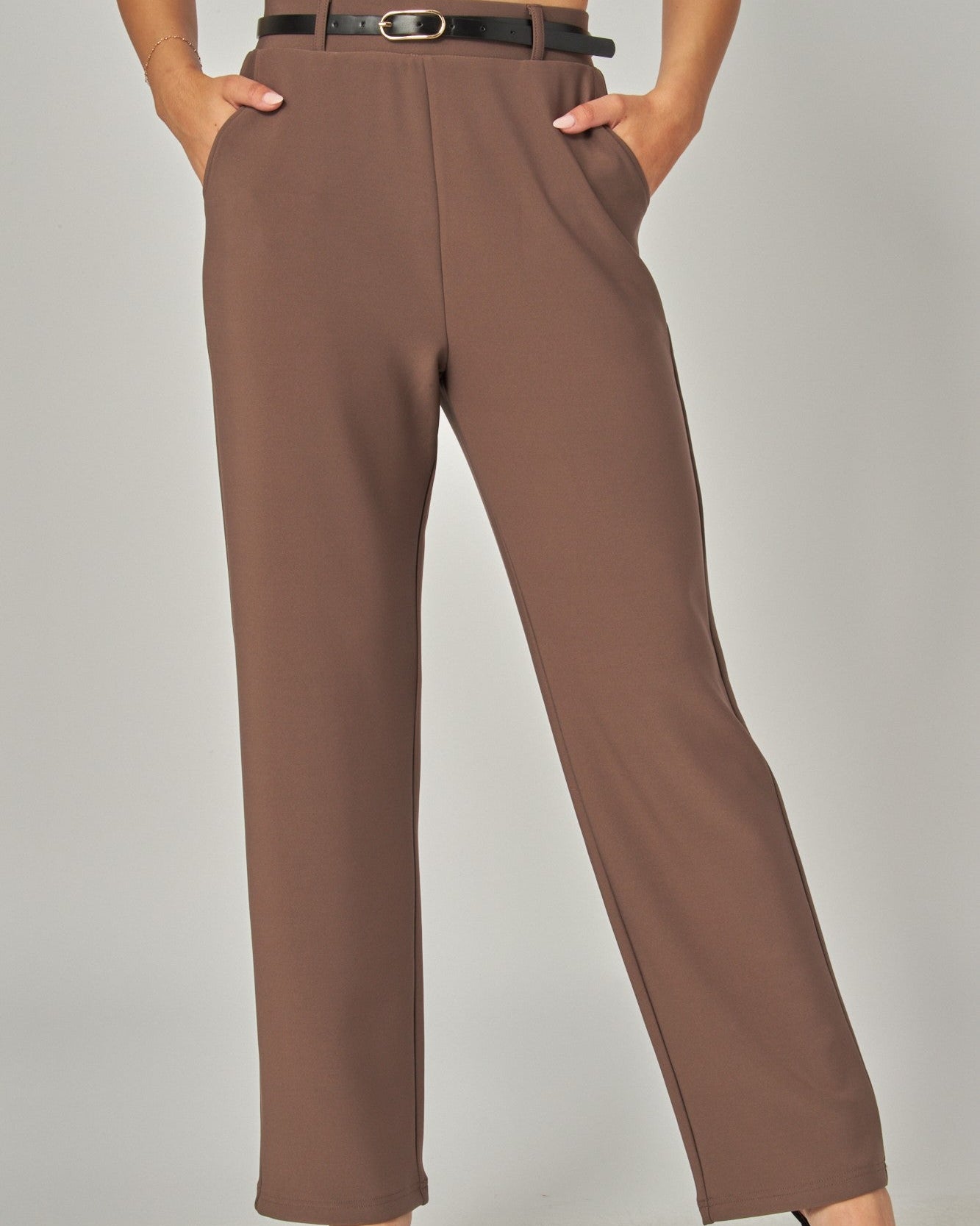 Brown pants worn by a person on a plain background