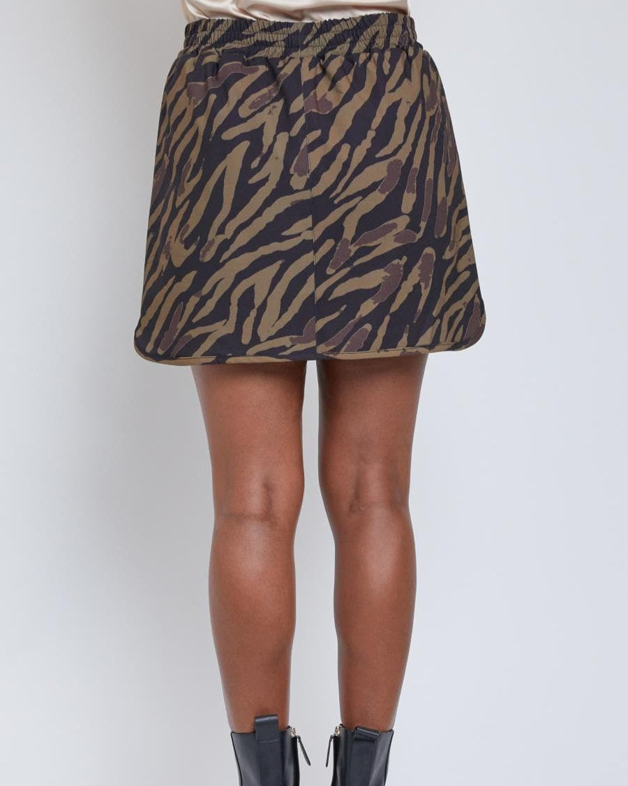 Rear view of tiger print skort styled with boots