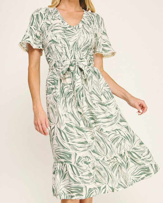 Woman wearing a green leaf-patterned dress on a white background