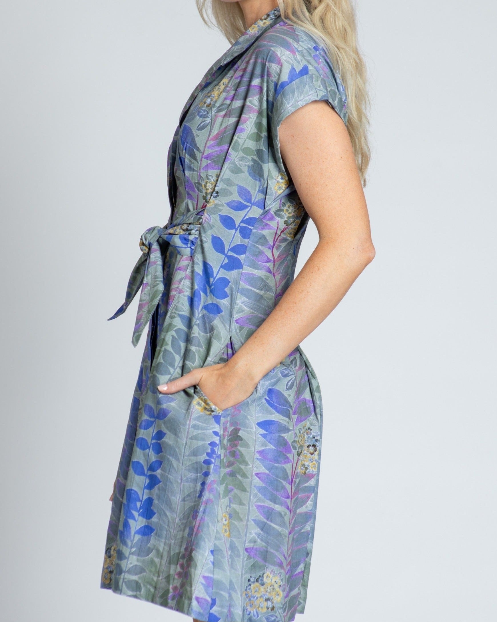 Woman wearing a floral dress with a plain background