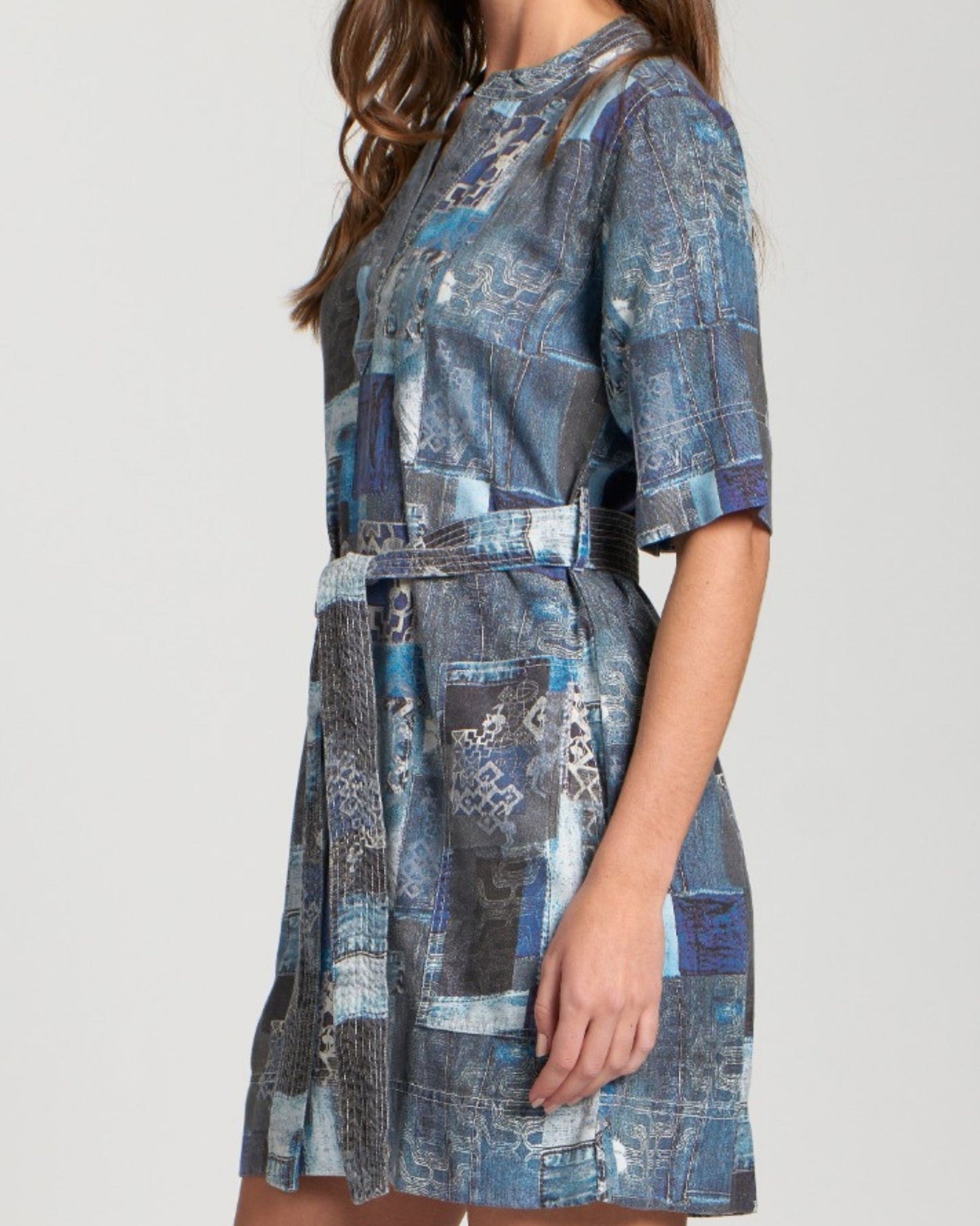 Woman wearing a blue patterned dress on a plain background