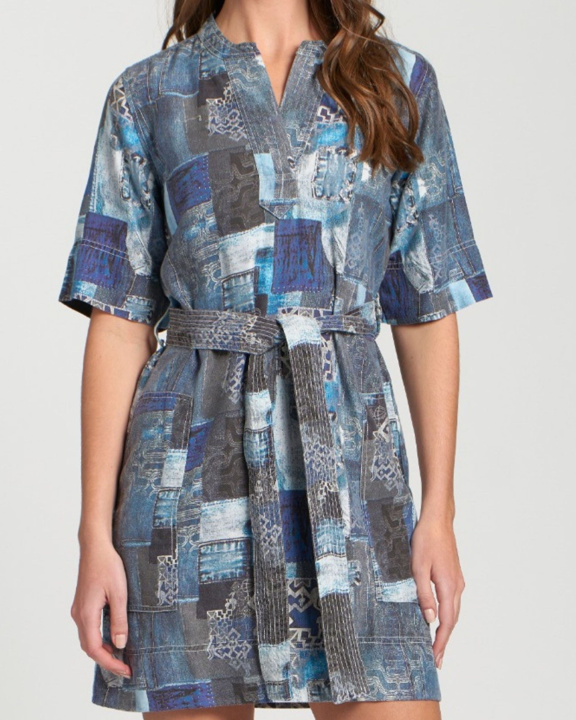 Woman wearing a blue patchwork dress on a white background