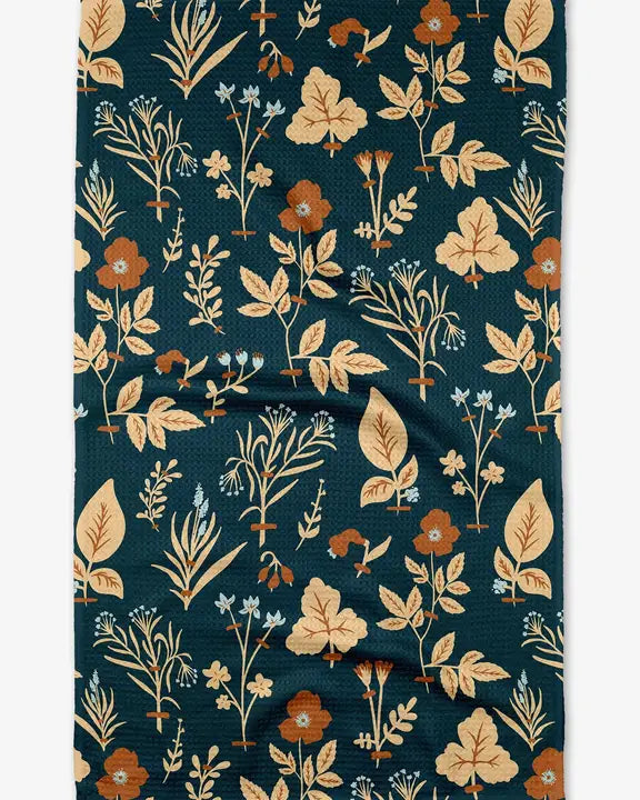Floral patterned fabric with leaves and flowers on a dark blue background