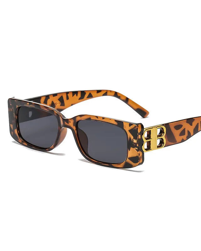 Sunglasses with leopard print frame and gold accents on a white background