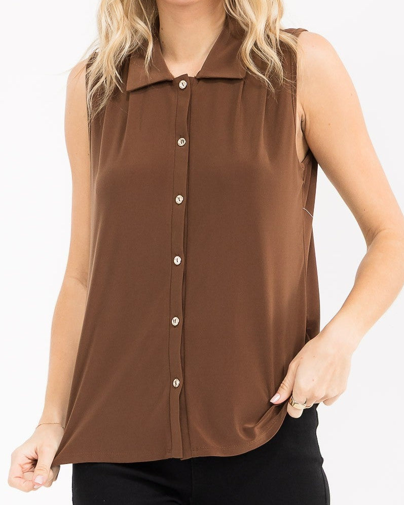 A woman modeling a sleeveless brown button-up top with a pointed collar, paired with black pants, against a plain white background.