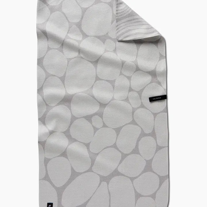 Folded fabric with a pattern of gray stones on a white background