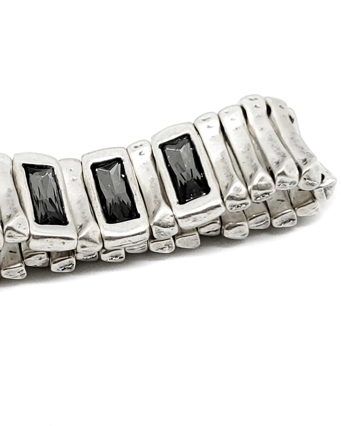 Silver ring with black gemstones on a white background