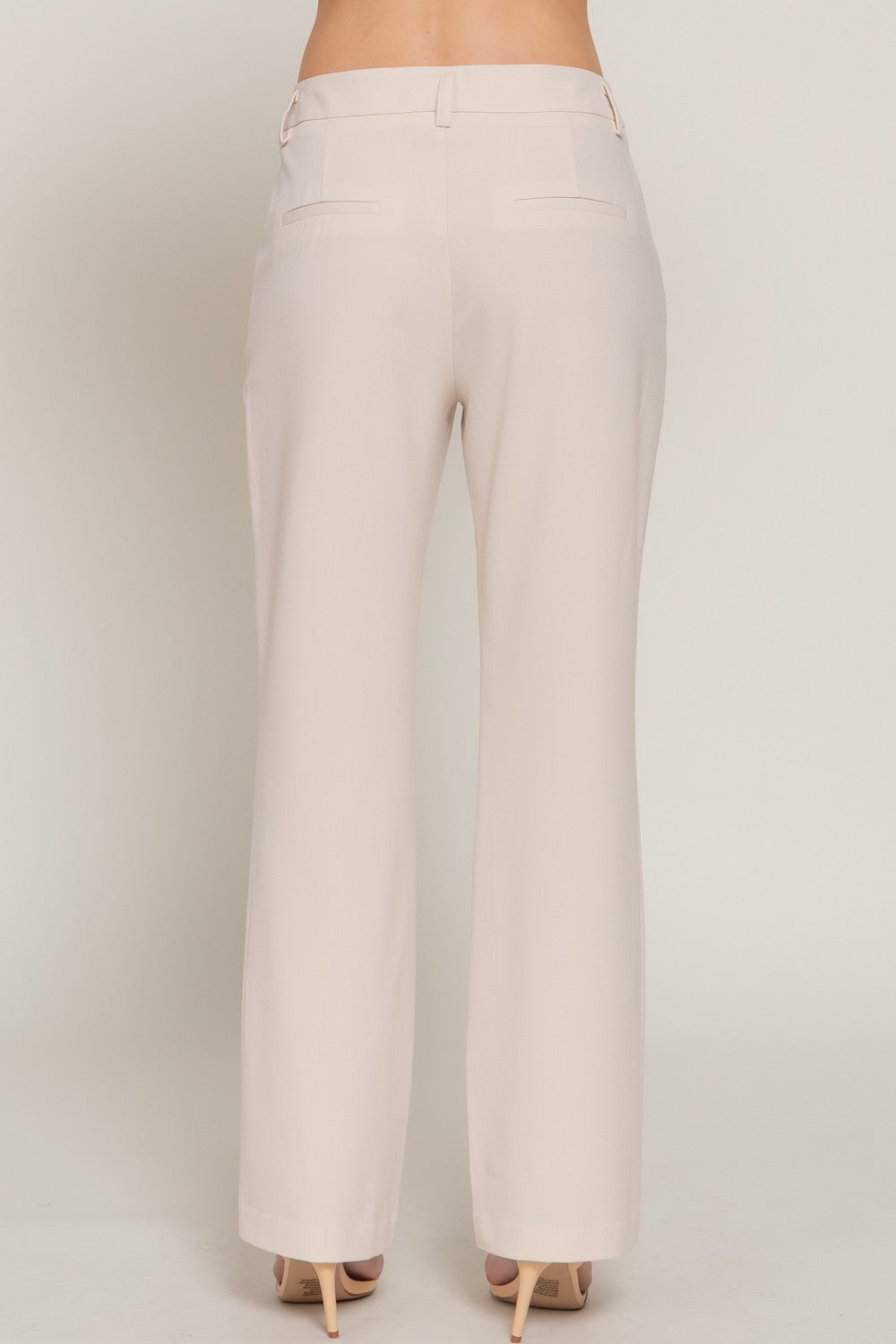 Beige pants worn by a person on a plain background