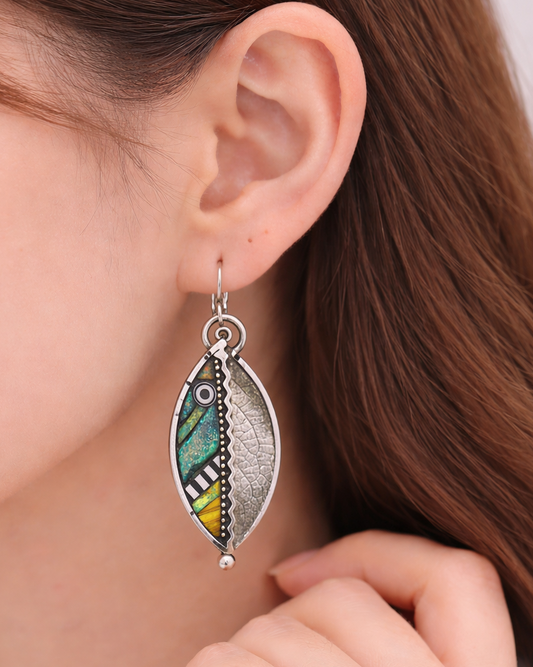 Close-up of a person wearing a colorful earring with a blurred background