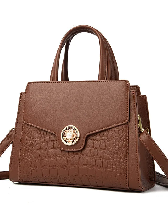 Brown handbag with gold clasp on a white background
