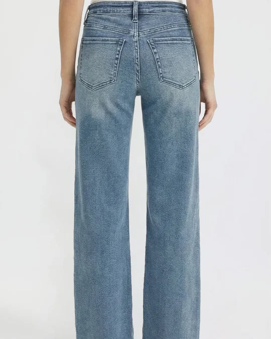 A person shown from the back wearing light blue wide-leg denim jeans against a plain white studio background.