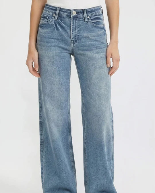 Person wearing light blue jeans on a white background