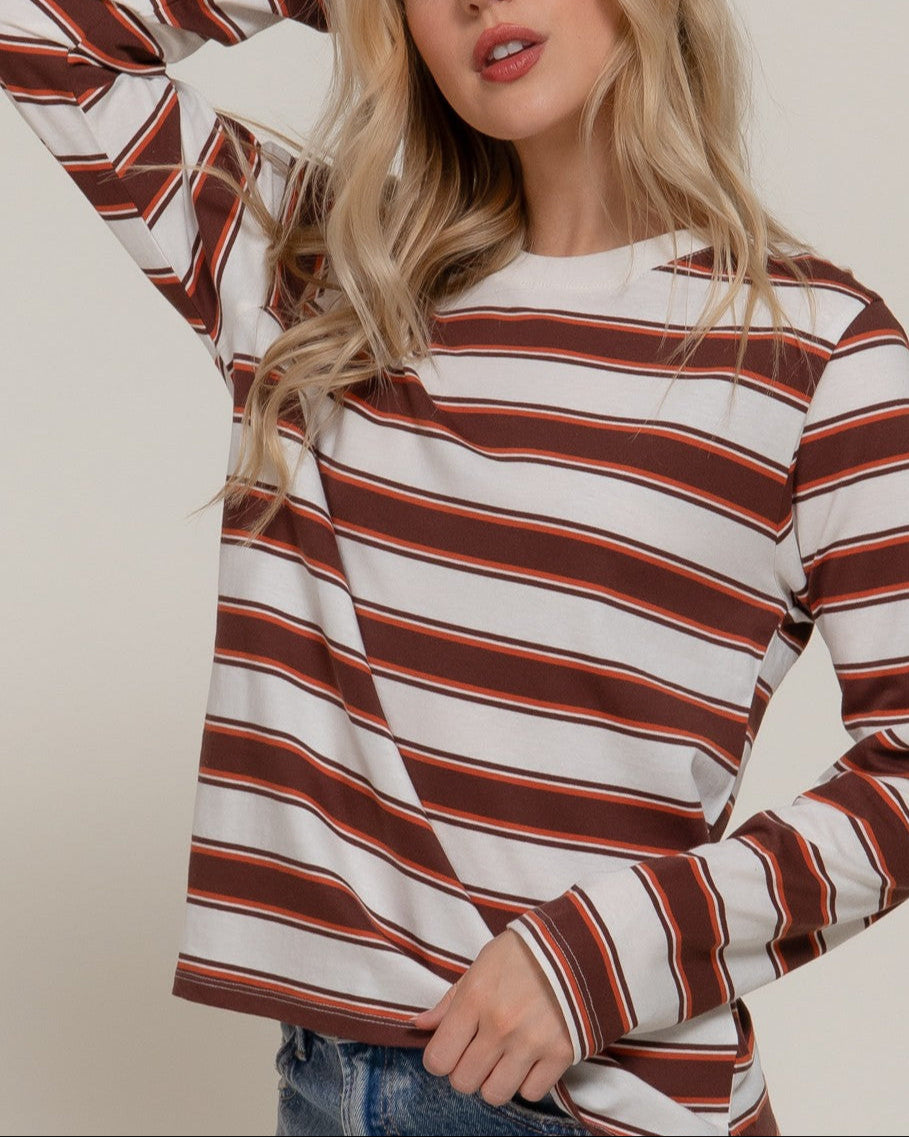 Woman wearing a striped long-sleeve top with a neutral background