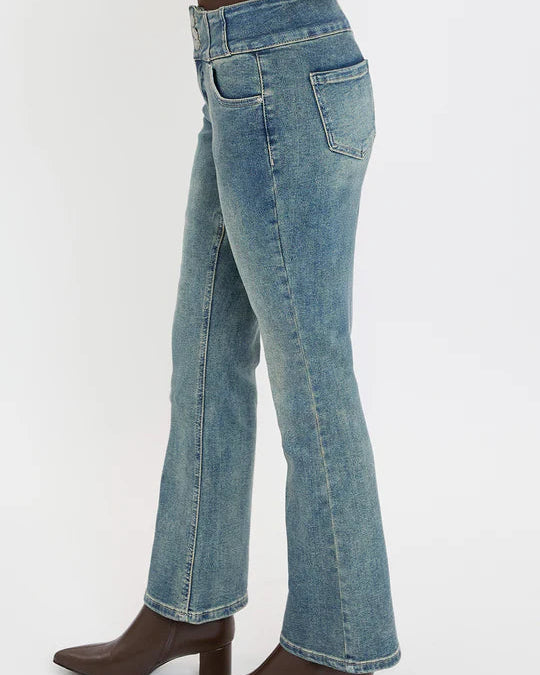 Blue jeans worn by a person on a white background