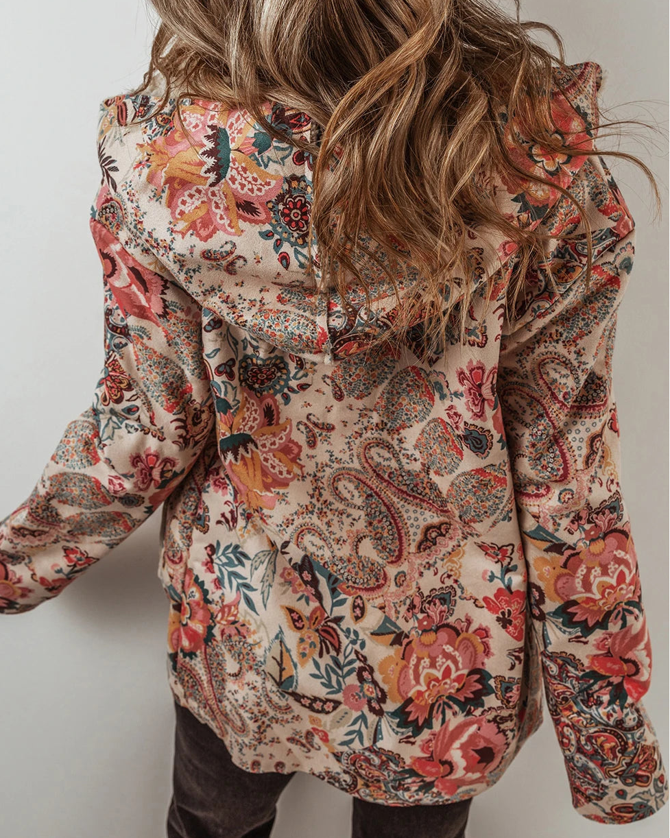 Person wearing a floral patterned jacket against a plain background