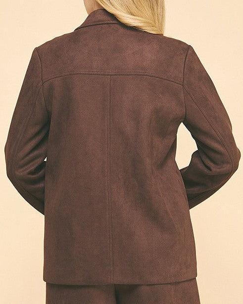 Brown suede jacket worn by a person on a beige background