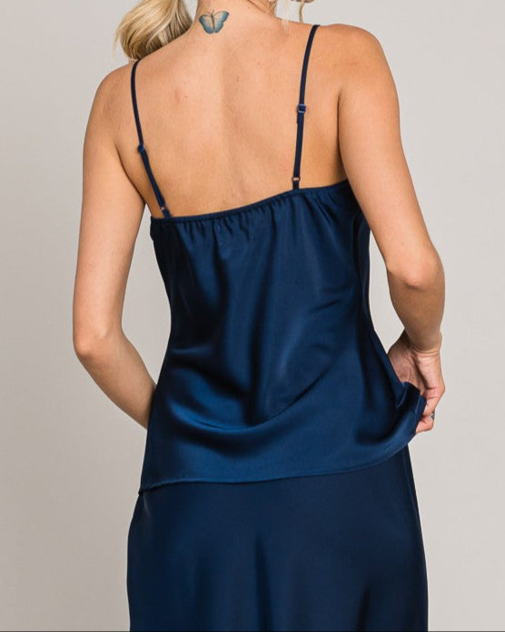 Woman wearing a blue satin nightgown against a plain background
