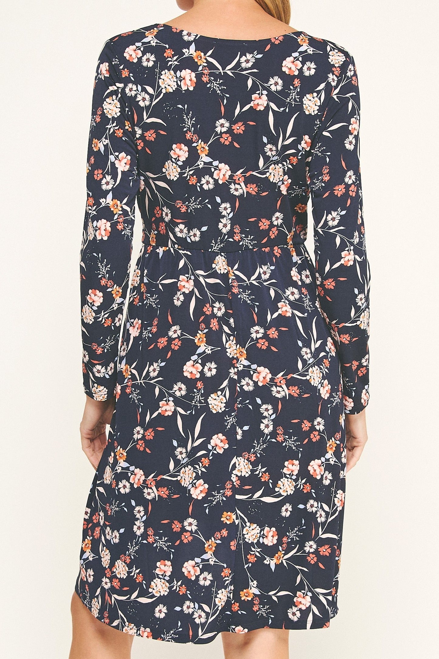 Woman wearing a navy floral dress on a white background