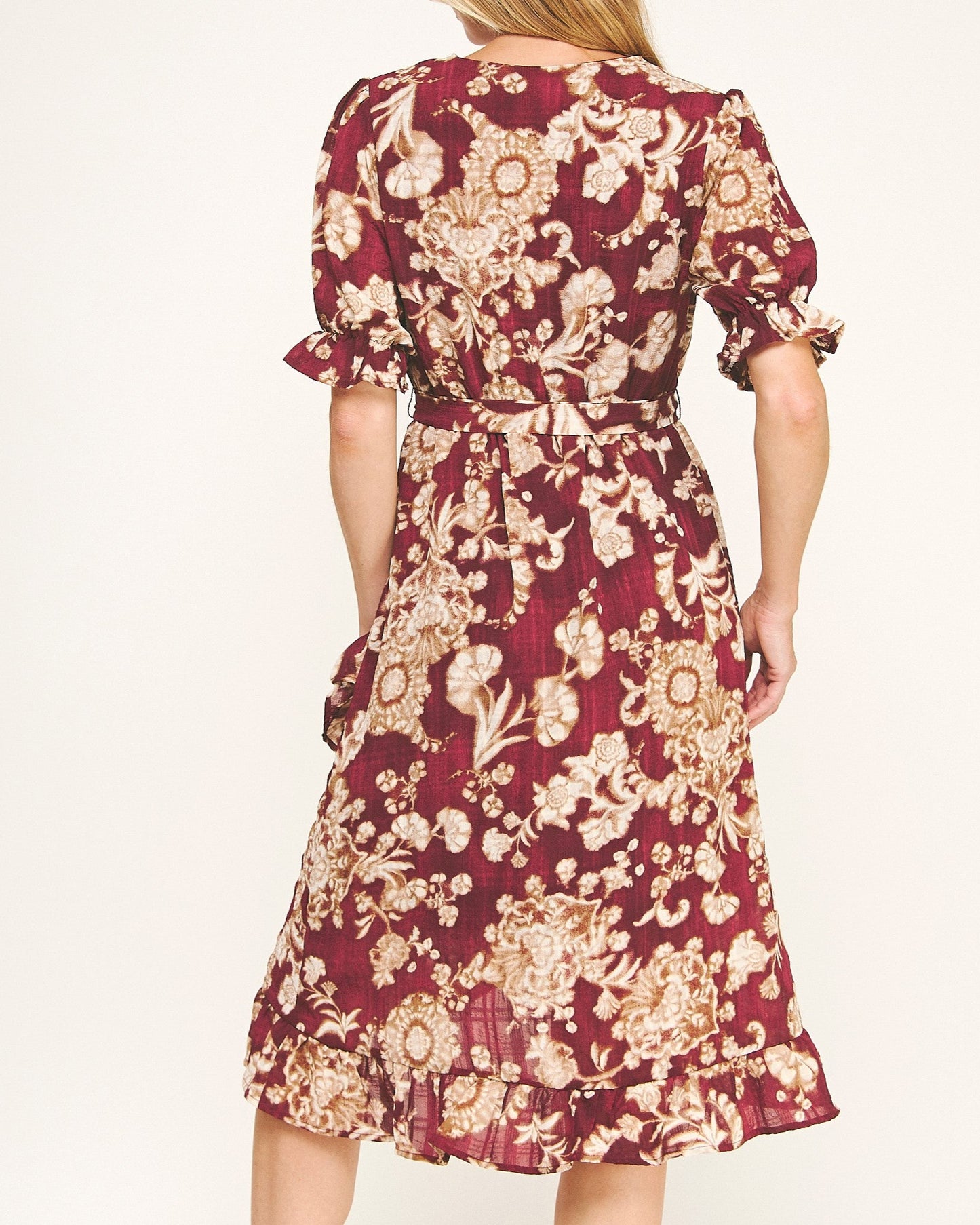 Woman wearing a burgundy floral dress on a white background