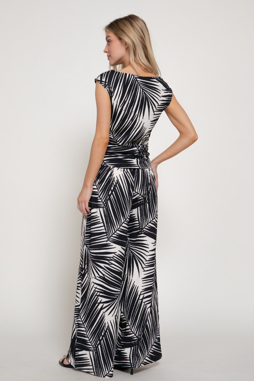 Woman wearing a black and white patterned dress on a plain background