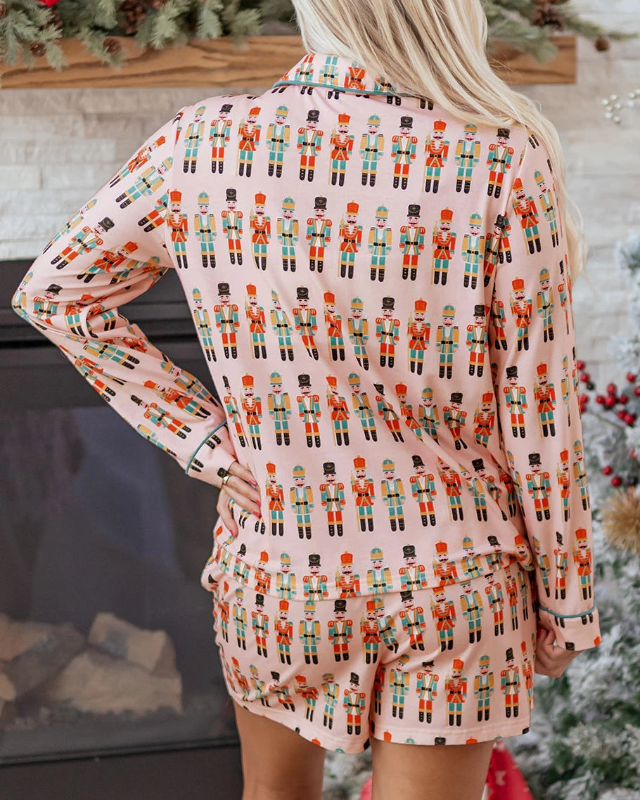 Person wearing a patterned outfit in front of a decorated fireplace and Christmas tree.