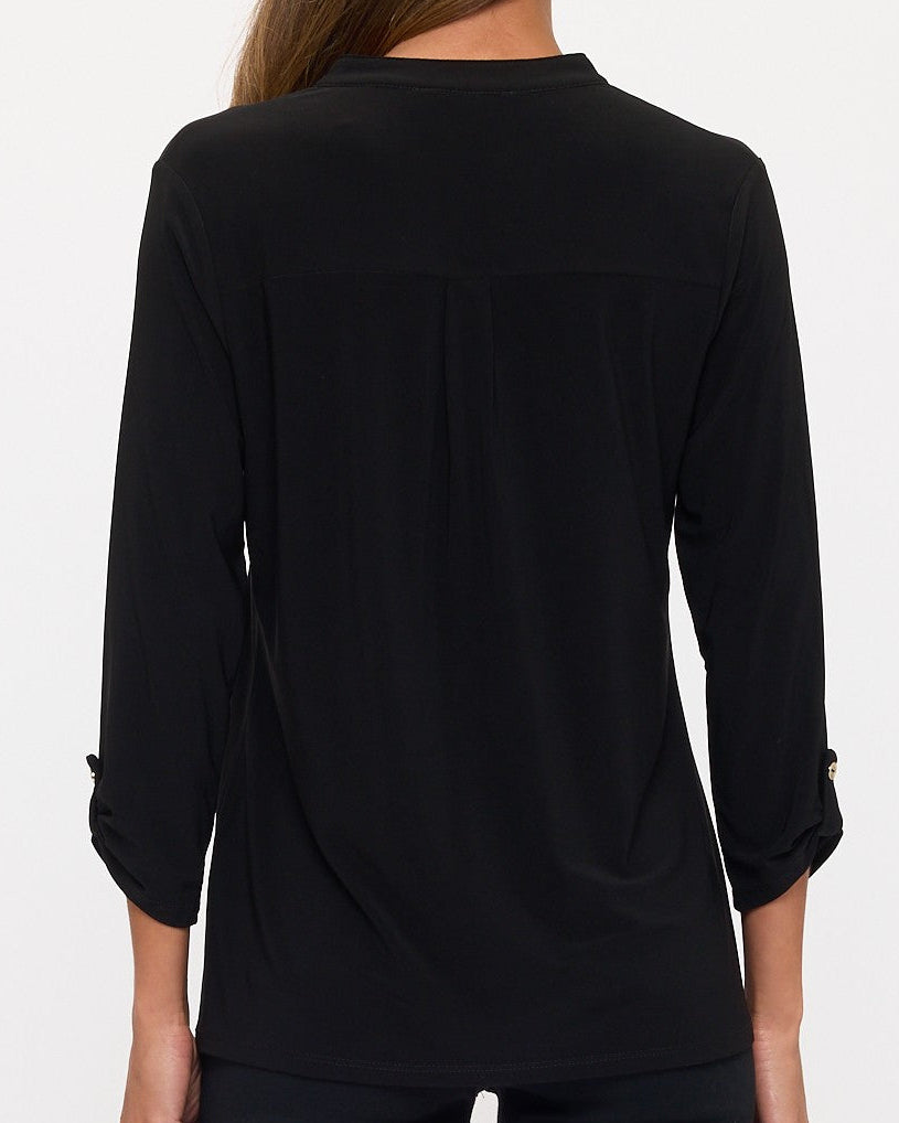 Black long-sleeve top worn by a person on a white background