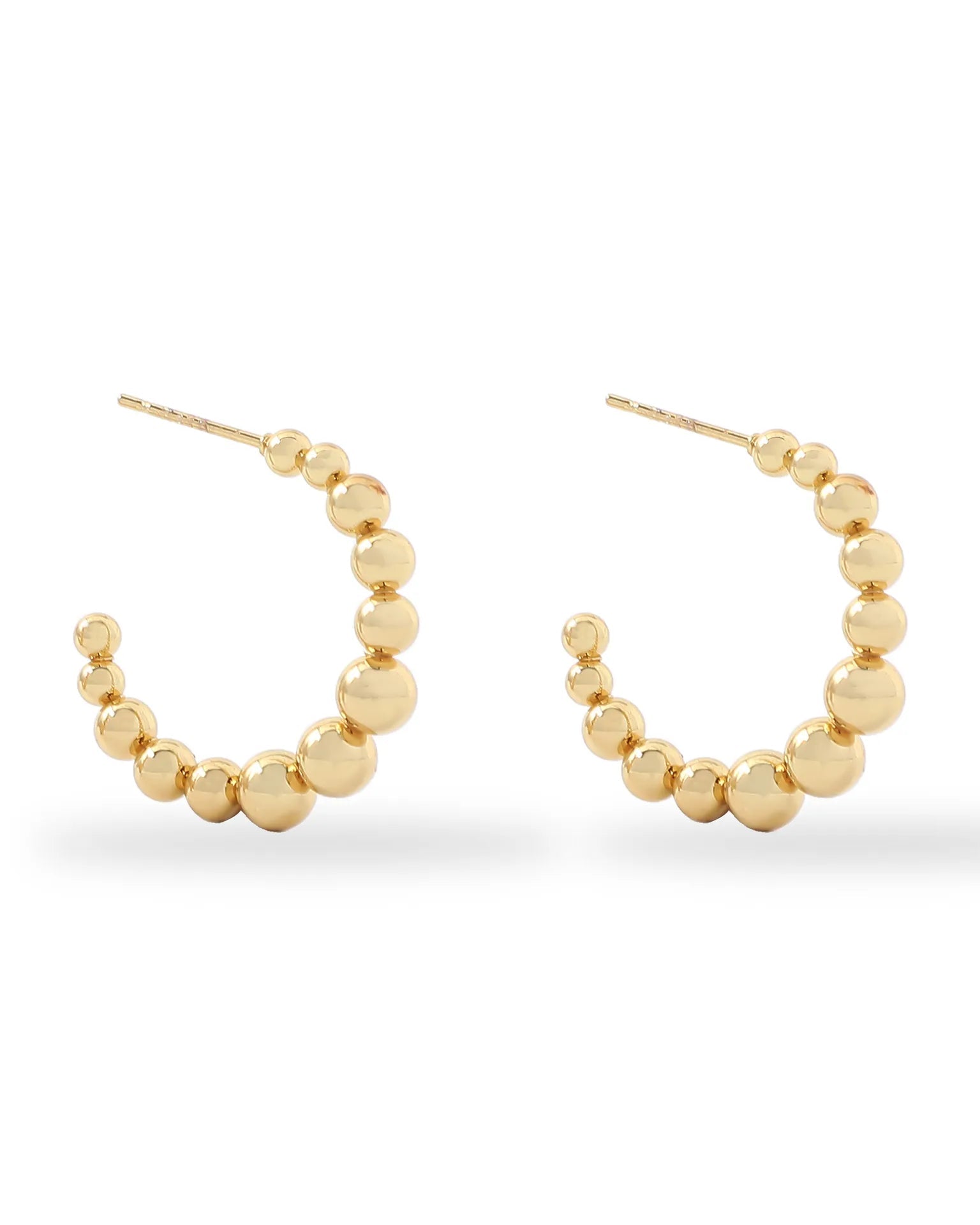 Gold hoop earrings with bead detailing on a white background