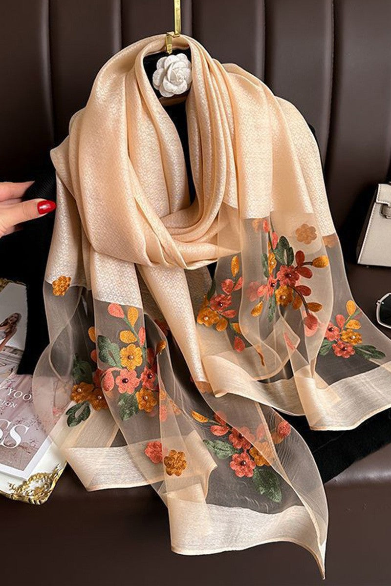 Beige scarf with floral patterns draped over a chair