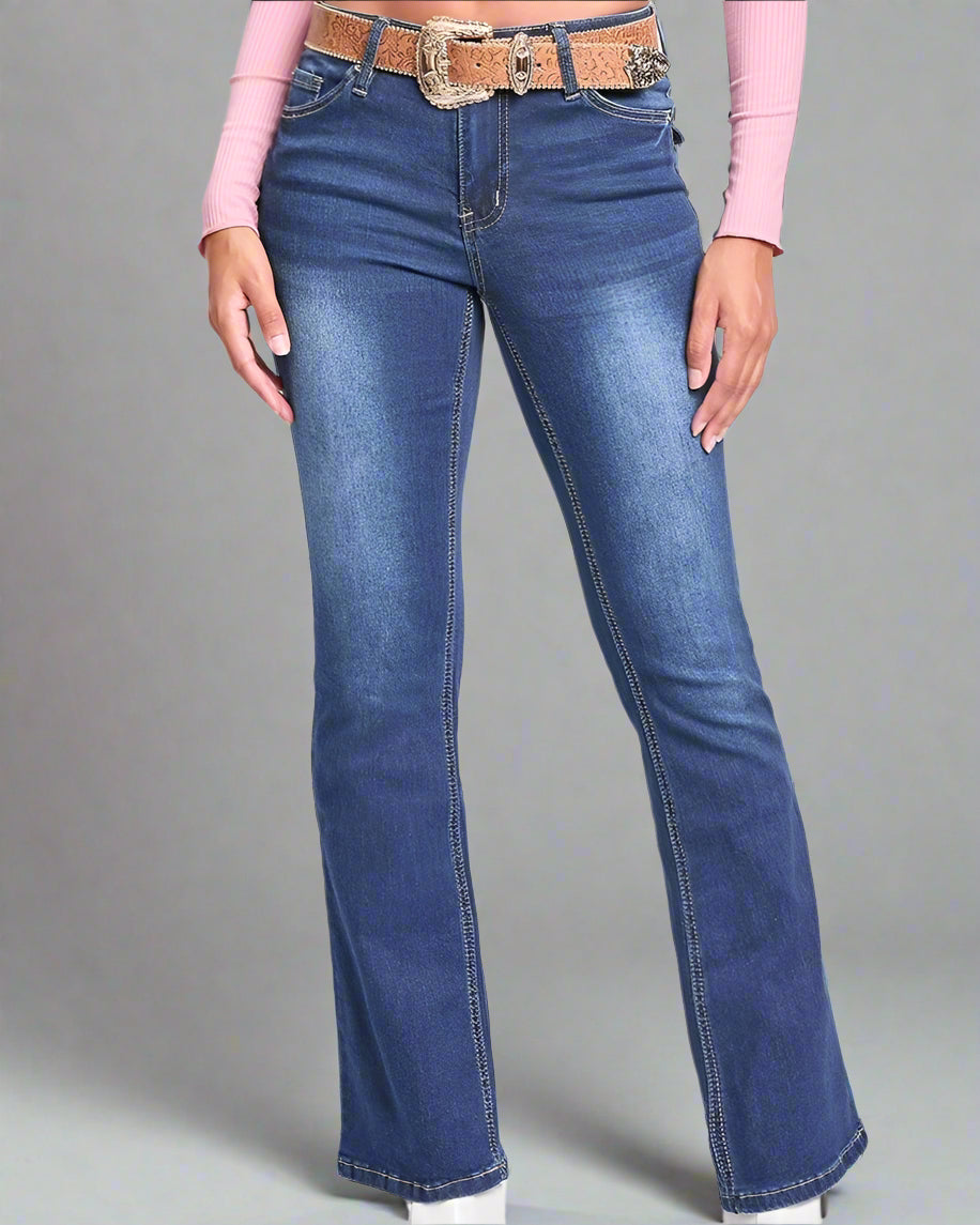 Woman wearing a pink top and blue jeans on a white background