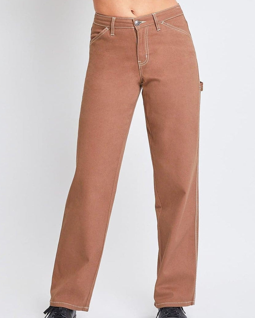 Woman wearing a white crop top and brown pants on a white background