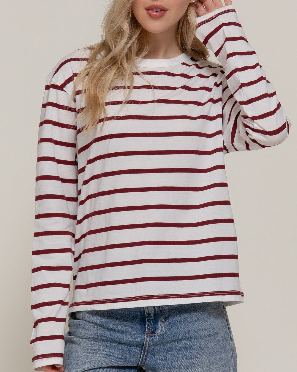 Woman wearing a red and white striped long-sleeve top against a plain background
